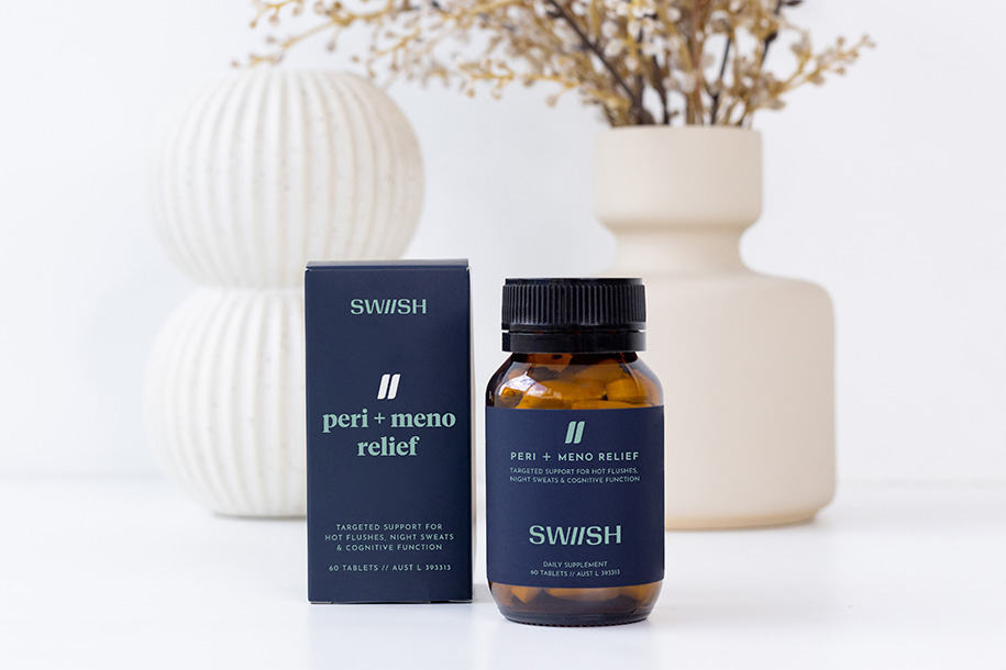 Bottle of SWIISH Peri + Meno Relief supplement beside its box in front of some neutral vases filled with flowers